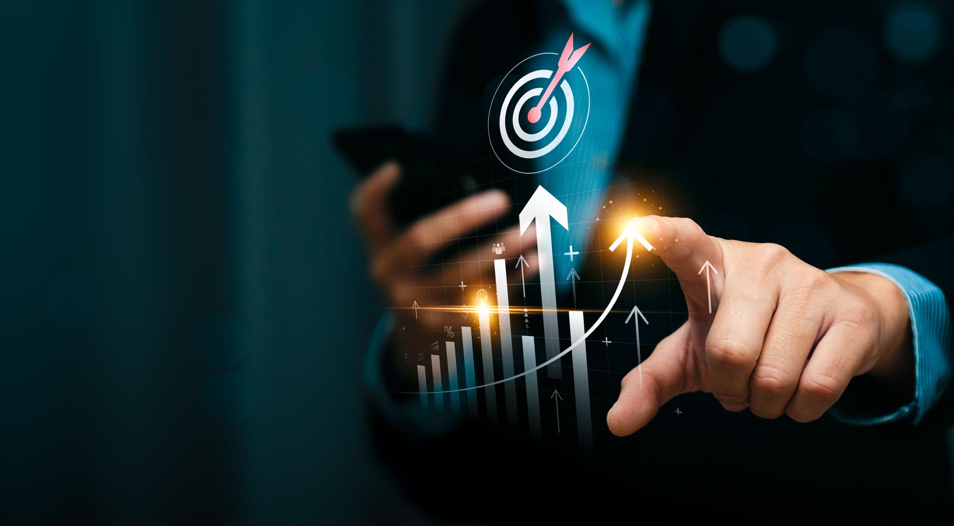 Business growth and success strategy with a businessman using a digital analytics interface, pointing at rising bar charts and a target, symbolizing financial performance, planning, and market trends.